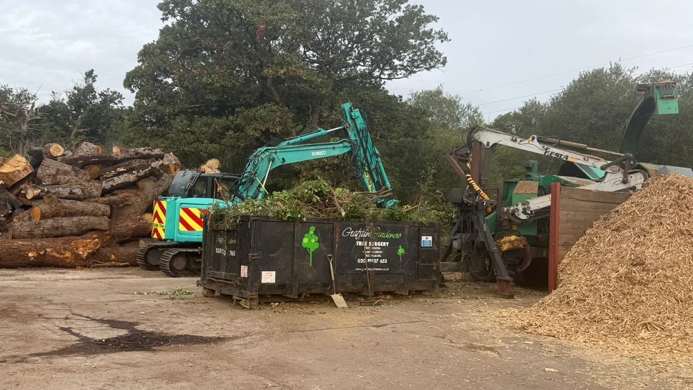 Log stacks, excavator and chipper at our trade green waste tipping site in Leatherhead, Surrey
